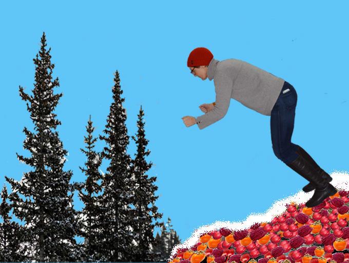 Deathbed Skiing: A woman in jeans and a jumper skiing - wihout skis or poles - down a hill of red and orange fruit