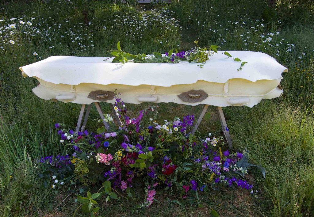 A felt cocoon -  much more gentle than a coffin. laid out in a country setting with some lovely flowers.  Contact https://bellacouche.com/
